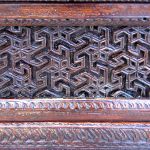 Detail of antique carved panel in finished buffet cabinet