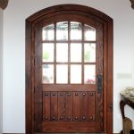 Arched entry with bubble glass and clavos