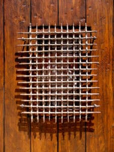 detail of grillwork on pintle-hinged door
